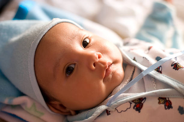 istock Hispanic male baby laying and looking at camera 121973984