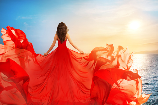 Woman Rear view in Red Flying Dress Fluttering on Wind, Girl in Waving Gown on Sundown Sea scene