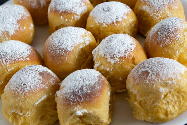 istock Round buns with white powdered sugar on a white plate side view 1219743930