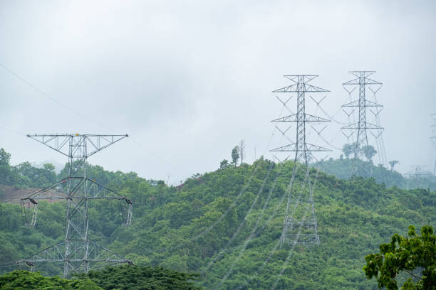 istock high voltage pole and line cable electrical transmission energy supply to industry in Mountain forest. 1219744528