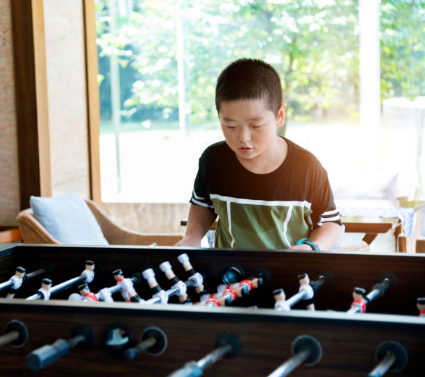 Two senior men playing table football (foosball) in an attic room. They laugh, cheer, shake hands, and enjoy a friendly competition. These images show active aging, friendship, and the joy of staying socially and mentally engaged in later life.
