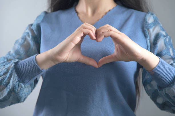 istock woman hand heart sign 1219748118