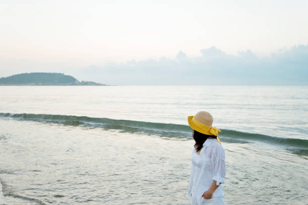 istock Young woman standing on beach 1219749623