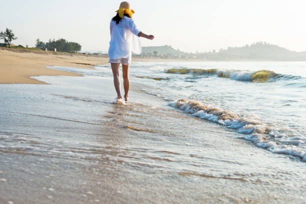 istock Woman walking on the beach 1219749944