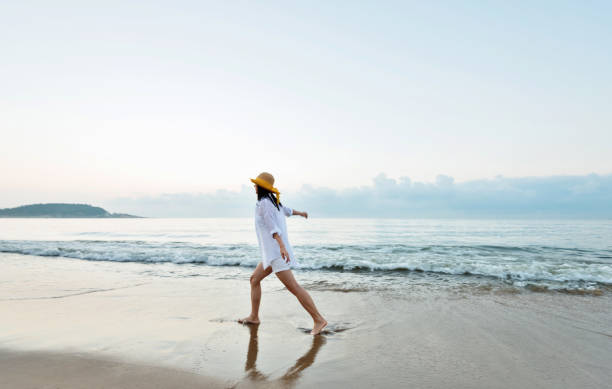 istock Woman walking on the beach 1219750237