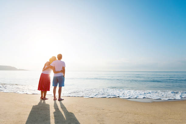 istock Couple standing on the beach 1219750788