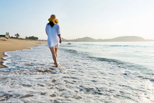istock Woman walking on the beach 1219750818