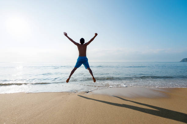 istock Excited man jumping on the beach 1219751060