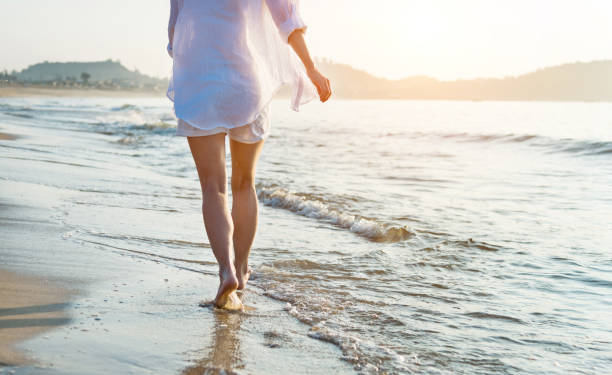 istock Woman leg walking on beach 1219751199