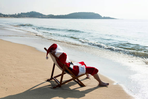 istock Santa Claus resting on deck chair at beach 1219751479