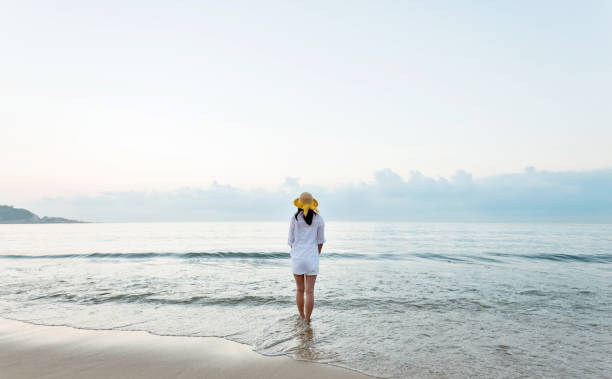 istock Young woman standing on beach 1219751557
