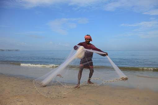Alleppey, India - September 16,2016 : An unidentified fisherman with his net engages in fishing the beach in Alleppey, Kerala, India