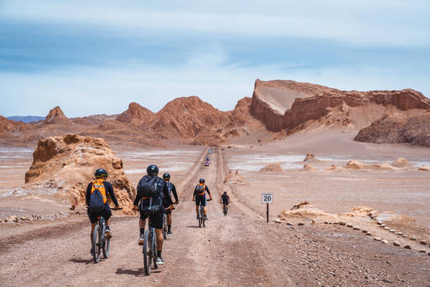 Cyclists at the Moon Valley in the Atacama Desert, Northern Chile, South America San Pedro de Atacama, Chile - February 20, 2020: Cyclists exploring the Moon Valley (Spanish: Valle de La Luna ) in the Atacama Desert near San Pedro de Atacama, northern Chile, South America. atacama region stock pictures, royalty-free photos & images