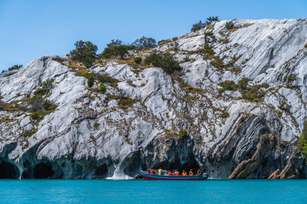 Tourists Exploring the Marble Caves in the General Carrera Lake in Chile, South America Puerto Rio Tranquilo, Chile - January 26, 2020: Tourists exploring the Marble Caves (Spanish: Cuevas de Marmol ), a series of sculpted caves and rock formations in the General Carrera Lake in Chile, South America. marble caves patagonia chile stock pictures, royalty-free photos & images