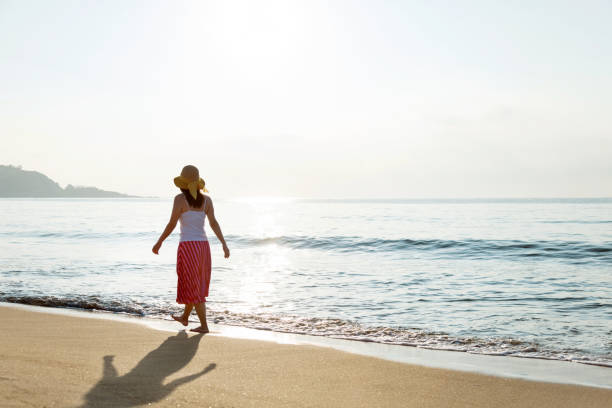 istock Woman walking on the beach 1219752470