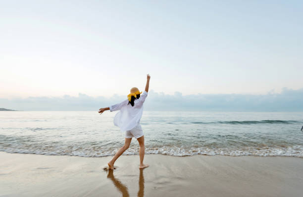 istock Happy woman playing on the beach 1219752602