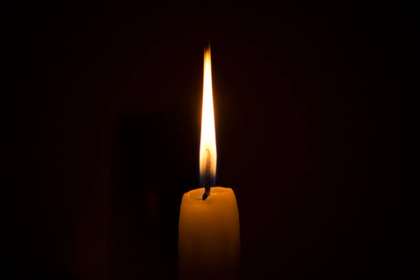 istock Candle flame in dark room 1219752748