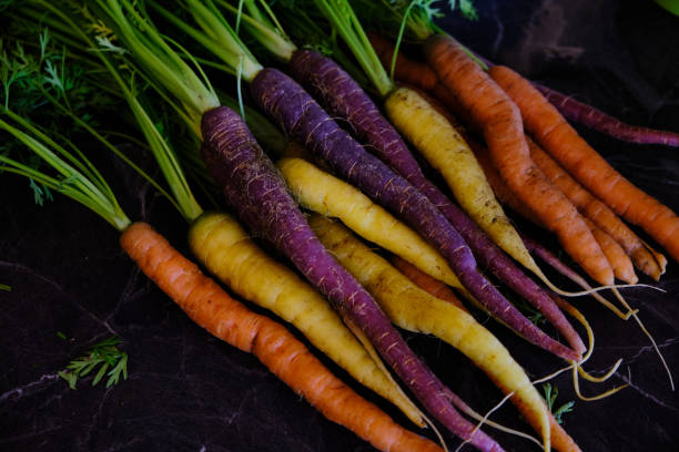 istock Colorful carrots, healthy vegetables on a black marble background 1219754664