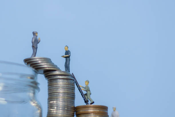 istock Miniature people standing on coins.and work on coins 1219755146