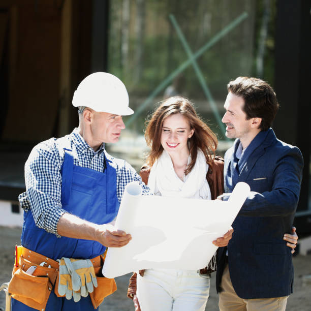 istock Foreman and couple with blueprint 1219755624