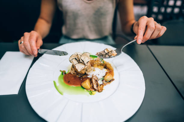 Woman eating colourful gourmet dinner with mushrooms,  potatoes, meat and sauce