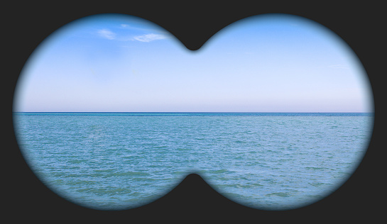 Sea view through binoculars. Seascape view via the field-glass.