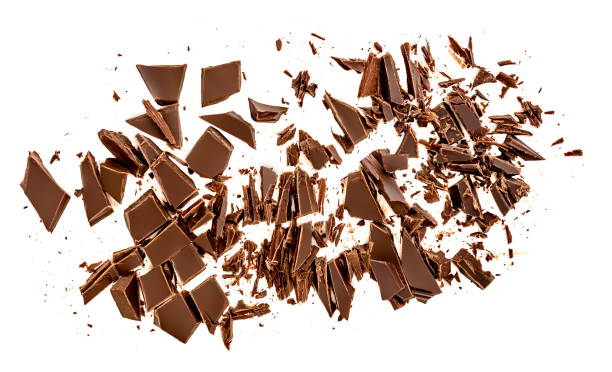 istock Dark chocolate pieces isolated on white background.  Chocolate bar chunks, shavings and cocoa crumbs Top view. 1219757850