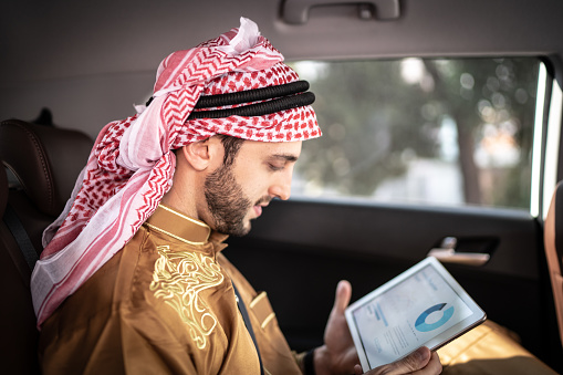 Arab Middle East man using digital tablet at car