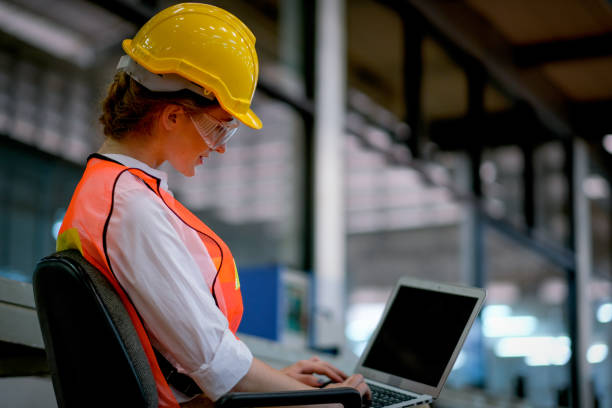 istock Pretty technician or engineer or worker sit on chair and use laptop in factory 1219760429