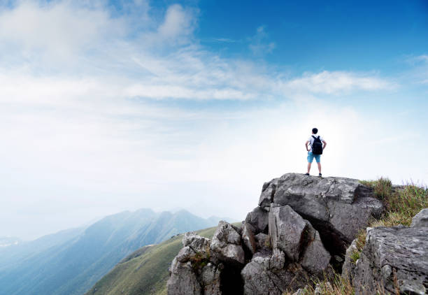 istock Man backpacker on the top of mountain 1219760487