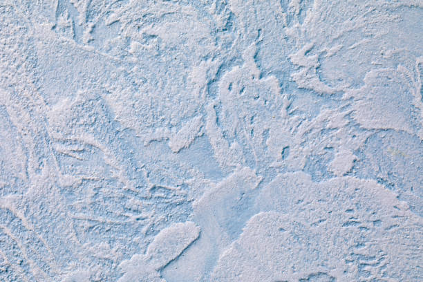 The relief blue wall is finished with decorative plaster. Abstract streaks like waves on a concrete wall. Design background on the theme of renovation of old housing, commercial real estate.