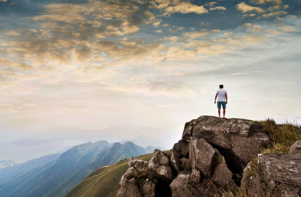 istock Man standing on the top of mountain at sunset 1219762386