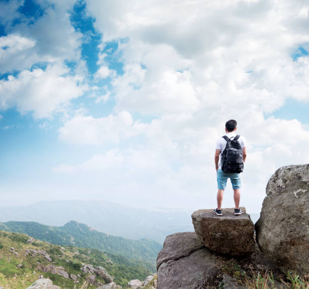 istock Man backpacker on the top of mountain 1219763320
