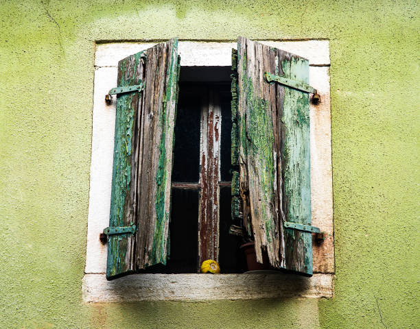 Old wooden window is falling apart and rotting