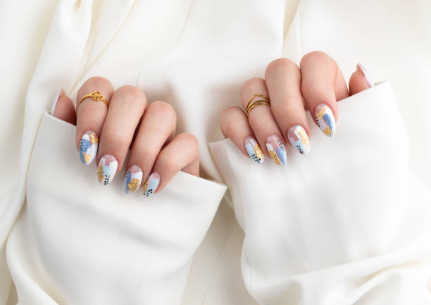 istock Woman's hand with fashionable nails holding fabric. 1219766763