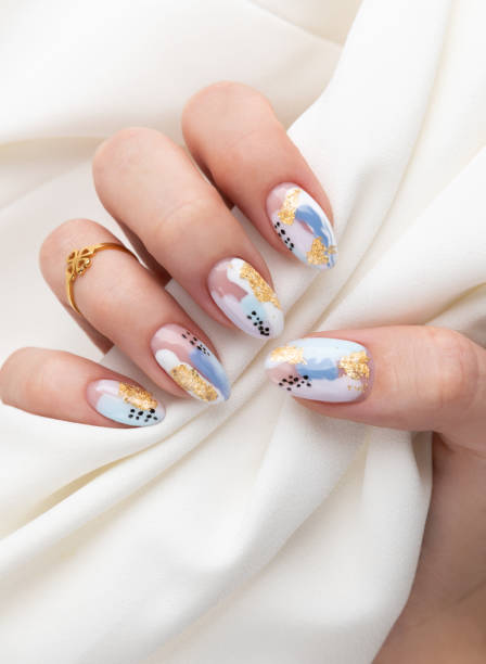 istock Woman's hand with fashionable nails holding fabric 1219766791