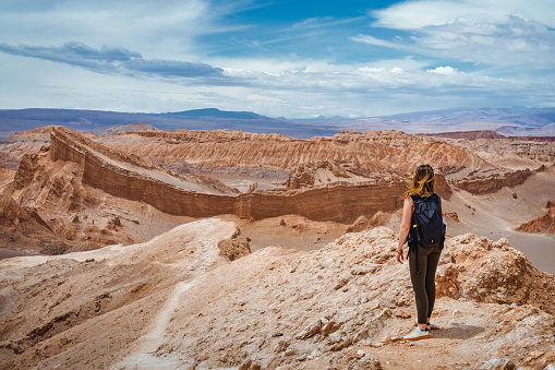 Young female traveller exploring the Moon Valley (Spanish: Valle de La Luna ) in the Atacama Desert, northern Chile, South America.