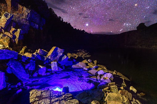Outdoor Natural Hot Springs Under the Stars - Night scenic view of stars and hot tub of rocks and silt in natural hot spring along scenic river with very dark skies and bright stars with Orion and Sirius visible..