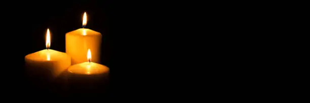 Photo of Flame candles isolated on black background.