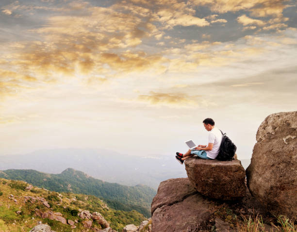 istock Man using laptop on top of mountain 1219768032
