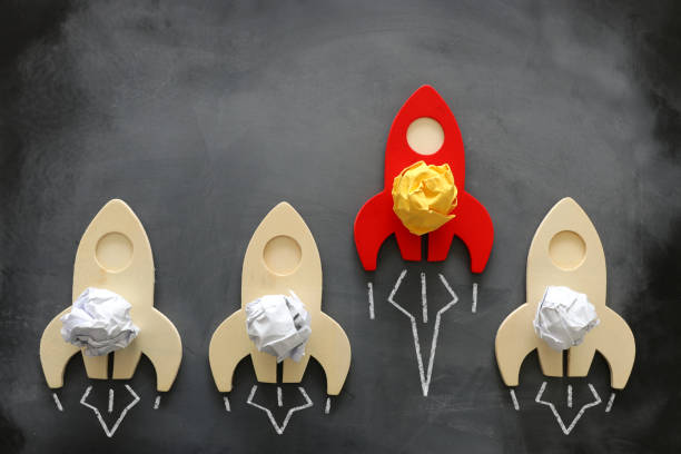 istock education or innovation concept. Wooden rocket over blackboard background. top view 1219768241
