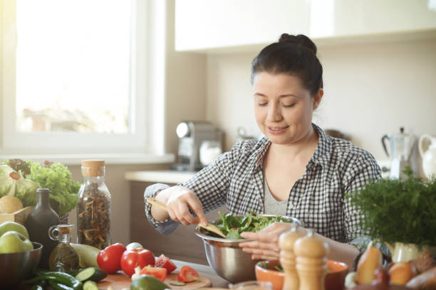 istock woman in the kitchen preparing food 1219768354