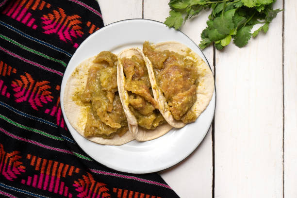 istock Mexican pork chicharron with green sauce tacos on white background 1219768394