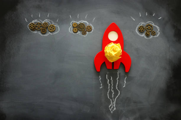 istock education or innovation concept. Wooden rocket over blackboard background. top view 1219768397