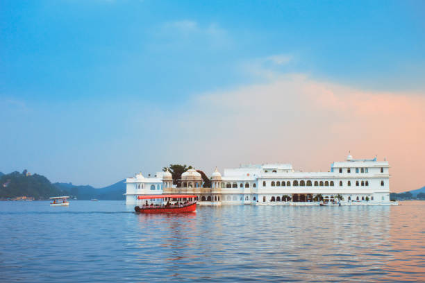 Lake Palace palace on Lake Pichola in twilight, Udaipur, Rajasthan, India Romantic luxury India travel tourism - tourist boat in front of Lake Palace (Jag Niwas) complex on Lake Pichola on sunset with dramatic sky, Udaipur, Rajasthan, India lake palace stock pictures, royalty-free photos & images