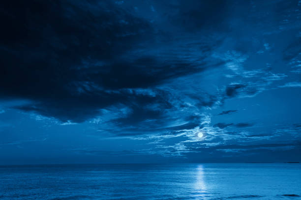 istock Bright Full Blue Moon Rises Over A Calm Ocean View 1219769187