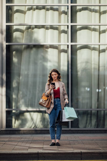istock Texting and Shopping: Woman Using a Smartphone on the Street While Shopping 1219772207