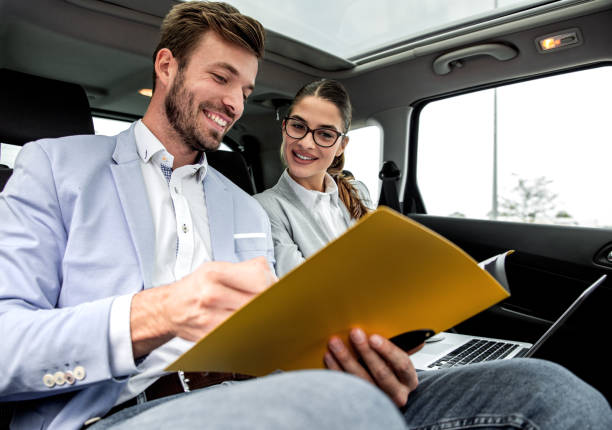 istock Young business people working together while traveling by a car. 1219772388
