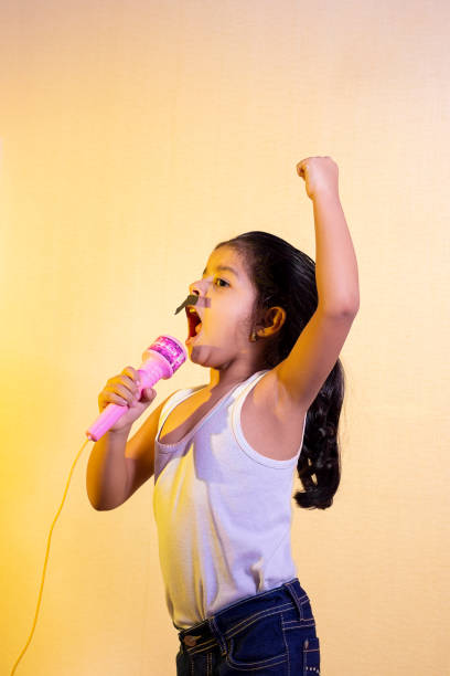 istock Little girl with a mustache singing using her microphone 1219772454