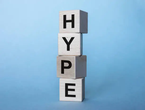 Photo of Hype inscription on wooden cubes on a gray-blue background